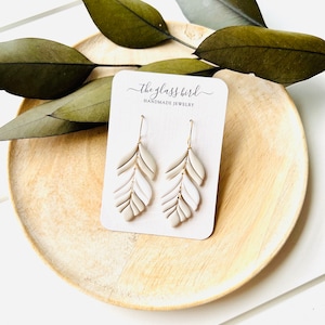 Pendientes de arcilla polimérica con plumas en tonos blanco y gris topo