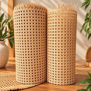 Puede incluir: Dos rollos cilíndricos de rejilla de ratán natural en color beige claro con un patrón de tejido octogonal consistente. El material presenta una estructura texturizada de tejido abierto con bordes deshilachados en la parte superior.