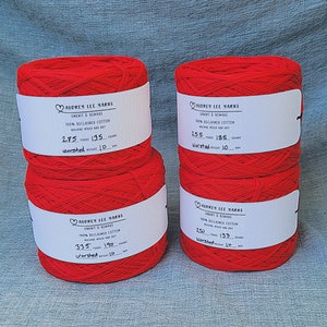May include: Three spools of red yarn labeled "Audrey Lee Yarns" with the text "Unknit & Remake 100% Reclaimed Cotton Machine Wash and Dry" and the yardage and weight of each spool.