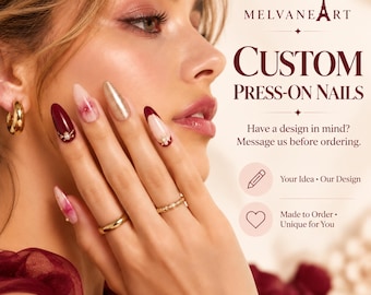 May include: Custom press-on nails by Melvaneart featuring almond-shaped tips in deep burgundy, soft pink marble, and metallic gold finishes, accented with small pearls and gold charms. Text reads: Custom Press-On Nails, Have a design in mind? Message us before ordering.