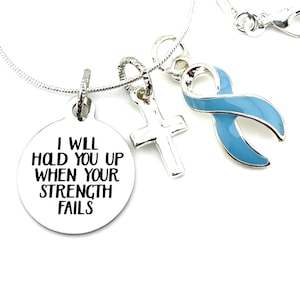 May include: Silver necklace with three charms: a round charm with the text "I will hold you up when your strength fails", a cross charm, and a light blue ribbon charm.