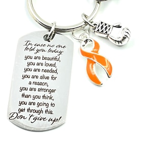 Puede incluir: Llavero de plata con un dije de cinta naranja, un dije de guante de boxeo plateado y una etiqueta plateada con el texto "En caso de que nadie te lo haya dicho hoy, eres hermosa, eres amada, eres necesaria, estás viva por una razón, eres más fuerte de lo que crees, vas a superar esto. ¡No te rindas!"