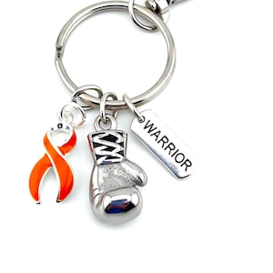 May include: Silver keychain with an orange ribbon, a silver boxing glove charm, and a silver tag that says "WARRIOR".