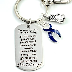 Peut inclure: Porte-clés argenté avec un charme de ruban bleu, un charme de gant de boxe argenté et une étiquette argentée avec le texte "Au cas où personne ne vous l'a dit aujourd'hui, vous êtes belle, vous êtes aimée, vous êtes nécessaire, vous êtes en vie pour une raison, vous êtes plus forte que vous ne le pensez, vous allez y arriver. N'abandonnez pas !"