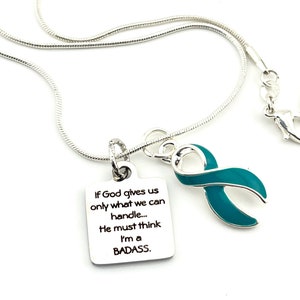 May include: Silver necklace with a teal ribbon charm and a silver pendant with the text "If God gives us only what we can handle... He must think I'm a BADASS."