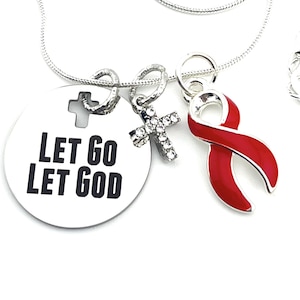 May include: Silver necklace with a round pendant that says "Let Go Let God". The pendant also has a small silver cross with rhinestones and a red ribbon charm.