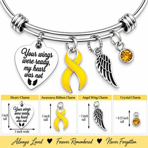 May include: A silver-tone expandable bangle bracelet featuring four charms: a heart engraved with 'Your wings were ready, my heart was not', a yellow awareness ribbon, an angel wing, and a yellow crystal. Includes dimension labels in inches.