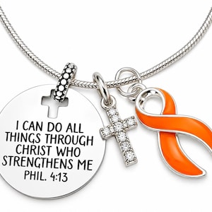 May include: A silver-toned chain necklace featuring three charms: a round metal disc engraved with the text I CAN DO ALL THINGS THROUGH CHRIST WHO STRENGTHENS ME PHIL. 4:13, a cross charm encrusted with clear stones, and an orange awareness ribbon.
