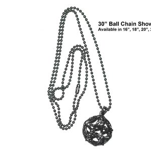 May include: A dark gray ball chain necklace with a geometric pendant. The necklace is shown at 30 inches, with other lengths available. The pendant is a dark gray, openwork sphere.