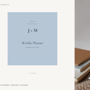 May include: A light blue digital PDF weekly planner with dark text reading J + M Weekly Planner. The design includes the text JUA + MOON PAPER CO. at the top and DIGITAL PDF PLANNER - UNDATED - 52 WEEKS at the bottom of the page.