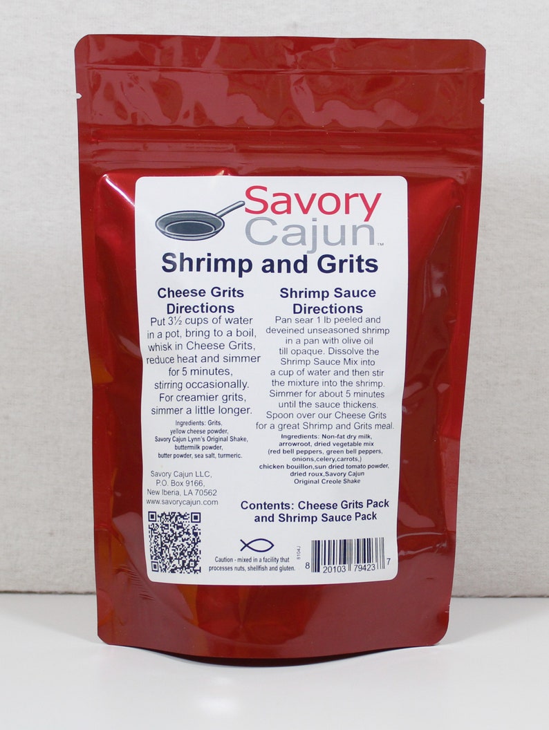 May include: A red resealable pouch with a white label that reads "Savory Cajun Shrimp and Grits". The label includes instructions for preparing cheese grits and shrimp sauce. The pouch contains a pack of cheese grits and a pack of shrimp sauce mix.