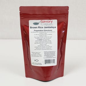 May include: A brown pouch of Savory Cajun Brown Rice Jambalaya mix. The label includes preparation directions and ingredient information. The pouch is sealed and ready for use. The product makes 4 cups as is, or 6 cups with meat or seafood.