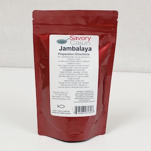 May include: A red resealable pouch with a white label that reads "Savory Cajun Jambalaya". The label includes instructions for preparing the jambalaya mix, which makes 4 cups. The label also lists the ingredients and nutritional information.