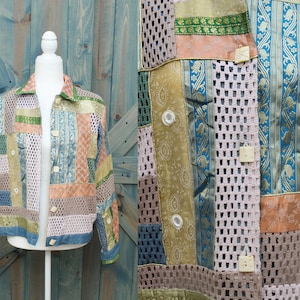 Puede incluir: Una chaqueta de patchwork hecha de retazos de tela de colores. La chaqueta tiene un diseño de malla de crochet y se abrocha con botones.