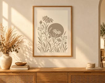 May include: A framed wall art print featuring a beige background with a taupe-coloured graphic illustration of various wildflowers, grasses, and a large solid circle representing the sun, all enclosed in a simple light wood frame.