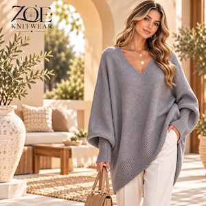 May include: A grey V-neck sweater with long sleeves and ribbed cuffs, paired with white trousers and a tan handbag. The text ZOE KNITWEAR is visible in the upper left corner, featuring a small floral icon above the word ZOE.