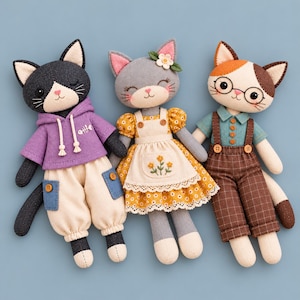 May include: Three plush cat dolls. The left cat wears a purple hoodie and cream pants. The center cat wears a yellow floral dress with a white apron. The right cat wears a teal shirt, brown plaid overalls, and round glasses.