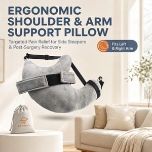 May include: A gray ergonomic shoulder and arm support pillow with black adjustable straps and a hook-and-loop closure. The text reads: ERGONOMIC SHOULDER & ARM SUPPORT PILLOW, Targeted Pain Relief for Side Sleepers & Post-Surgery Recovery, Fits Left & Right Arm. Includes a small beige drawstring bag with the logo SAHEYER.