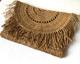 May include: A brown crocheted bag with a fringe border. The bag has a circular design with openwork details.