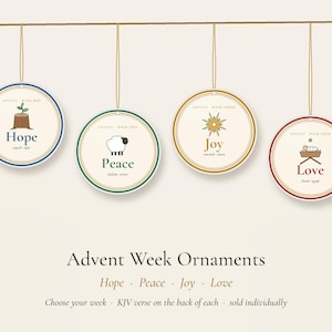 May include: Four circular hanging ornaments labeled Advent Week One through Four. Each features a unique icon: a tree stump for Hope, a sheep for Peace, a star for Joy, and a manger for Love. The text includes the words Hope, Peace, Joy, and Love.