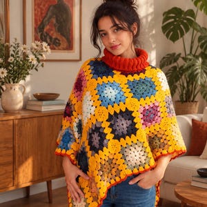 Op de afbeelding: Een gehaakte poncho met een levendig granny square-patroon in tinten geel, blauw, paars en wit, afgewerkt met een dikke rode geribbelde col en een bijpassende rode geschulpte rand langs de onderkant van de zoom.