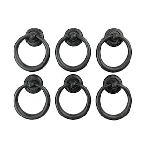 May include: Six black metal ring pulls with a circular design. The pulls have a smooth, slightly distressed finish.