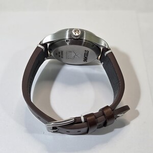 May include: A wristwatch with a brown leather strap and a silver-toned stainless steel case. The back of the watch case features the text STEELWING, HILL TIMEPIECES, STAINLESS CASE, and 50m 165ft.