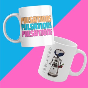 May include: Two white ceramic mugs. One mug features the word "PULSATIONS" repeated three times in orange, blue, and pink. The other mug features a white robot with a blue face holding a bouquet of red flowers. The text "PULSAR" is written vertically on the side of the mug.