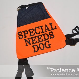 May include: Orange safety vest with black straps and a black embroidered label that reads "SPECIAL NEEDS DOG".