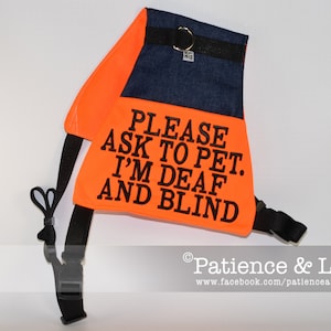 May include: Orange and blue dog harness with the text "PLEASE ASK TO PET. I'M DEAF AND BLIND".