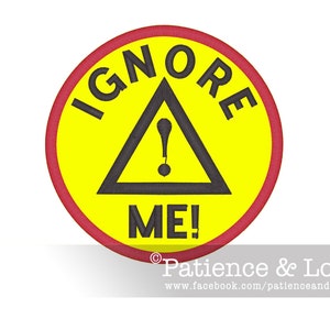 Könnte beinhalten: Ein gelber Kreis mit rotem Rand und einem schwarzen Dreieck mit einem Ausrufezeichen darin. Der Text "IGNORE ME!" ist um das Dreieck herum geschrieben.