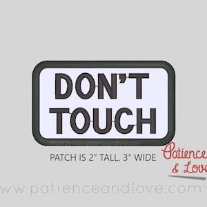 May include: A white rectangular patch with black embroidered text that reads "DON'T TOUCH". The patch is 2 inches tall and 3 inches wide. The text "PATCH IS 2" TALL, 3" WIDE" is printed below the patch.