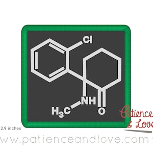 May include: A green square patch with a white chemical structure diagram on a black background. The chemical structure includes a benzene ring, a six-membered ring, and the text "Cl", "NH", "O", and "H3C".