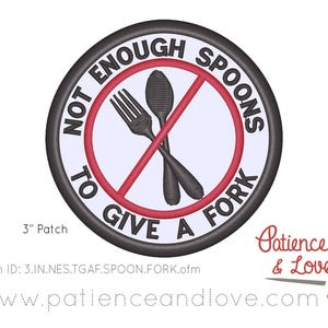 May include: A 3-inch round black and white embroidered patch with a red circle and diagonal red line through it. The text "Not Enough Spoons To Give A Fork" is written around the circle. Inside the circle are a fork and spoon crossed over each other.