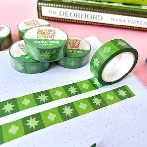 May include: Green and white washi tape rolls with a repeating pattern of stars and clouds. The tape is labelled "Stacey McVey Chunt. Washi Tape 15mm x 10m".