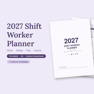 May include: A 2027 Shift Worker Planner with a white cover featuring dark purple text. The planner includes sections for Rota, Sleep, Pay, and Leave. A tan pen rests on the open calendar page, which displays a grid layout for tracking shifts.