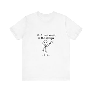 以下が含まれることがあります： 白い半袖Tシャツで、手を振る棒人間の黒い線画が描かれています。棒人間の上には、「No AI was used in this design」というテキストが、胸の中央にシンプルな黒のサンセリフ体でプリントされています。