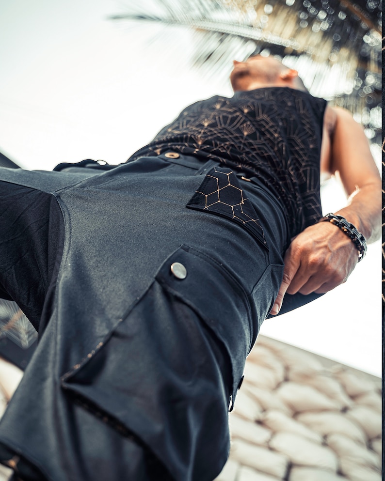 May include: Black cargo pants with a honeycomb-patterned pocket and a silver button. The pants are made of a soft, comfortable fabric.