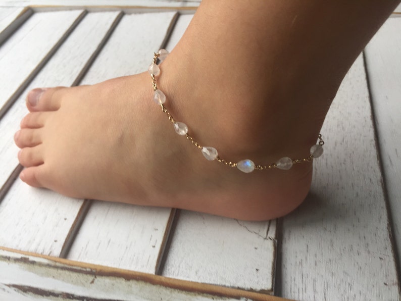 May include: A gold chain anklet with white moonstone beads.