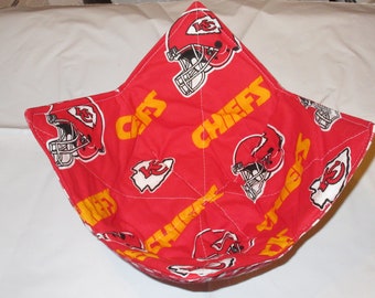 May include: A red fabric bowl with a repeating pattern of yellow and white Kansas City Chiefs football helmets and logos. The word "CHIEFS" is printed in yellow. The bowl is quilted with white stitching.