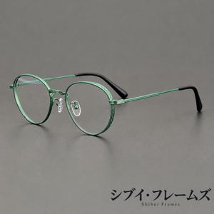 Montura de gafas pequeña, redondeada, de color verde, con detalle decorativo en el borde y patillas finas.
