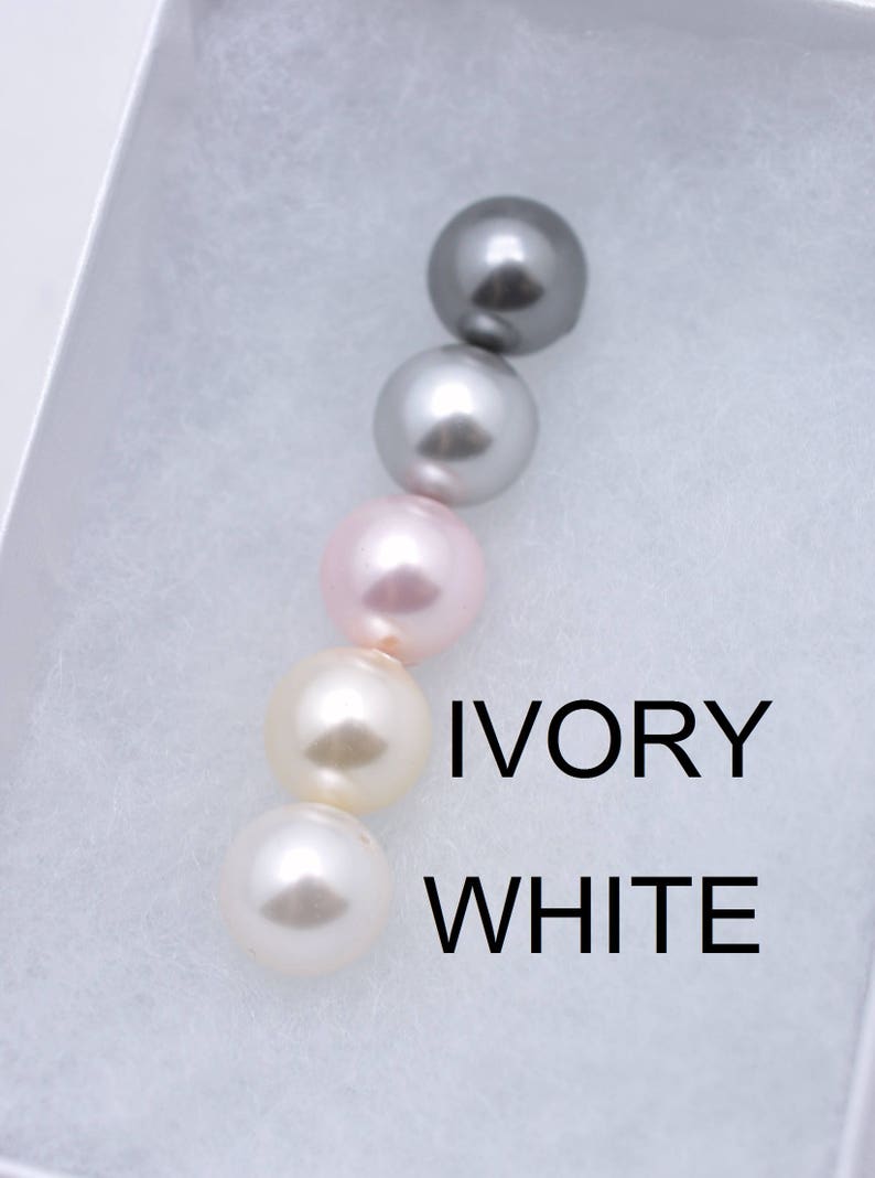 Puede incluir: Cinco perlas en fila, de izquierda a derecha: gris, plata, rosa claro, marfil y blanco. El texto "IVORY" y "WHITE" est&aacute; escrito debajo de las perlas.