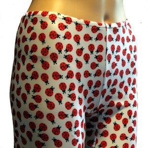 May include: White leggings with a red and black ladybug print.