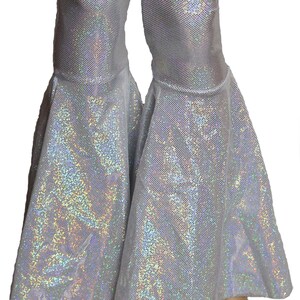 May include: White flared pants with a shimmering iridescent finish. The pants have a wide leg opening and a fitted waist.