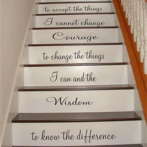 May include: A staircase with white risers featuring black vinyl lettering that reads: God Grant me the Serenity to accept the things I cannot change Courage to change the things I can and the Wisdom to know the difference, with dark wood treads.