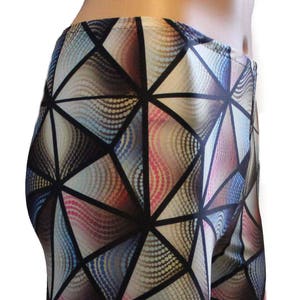 Puede incluir: Leggings con estampado geométrico en un esquema de colores negro, blanco, azul, rosa y marrón. El patrón está formado por triángulos y círculos.