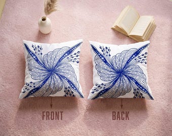 May include: Two square throw pillows featuring a white base with a blue swirling floral pattern. The left pillow is labeled FRONT and the right pillow is labeled BACK. The design consists of radiating blue lines and circular dots.