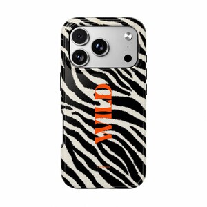 May include: A smartphone case featuring a black and white zebra stripe pattern. The word WILD is printed vertically in bold orange capital letters in the center. The brand name Coletta is printed in small orange letters near the bottom edge.