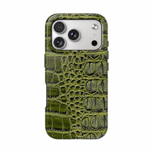 Puede incluir: Una funda para smartphone con un patrón texturizado de piel de cocodrilo en color verde oliva. La funda tiene un recorte rectangular para la cámara en la parte superior con tres lentes circulares y un flash. La palabra Gioletta está impresa abajo.