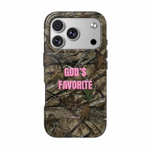 May include: A smartphone case featuring a brown and green forest camouflage pattern with the text GOD'S FAVORITE printed in bold pink letters across the center and the brand name Gioletta in small pink text near the bottom edge.